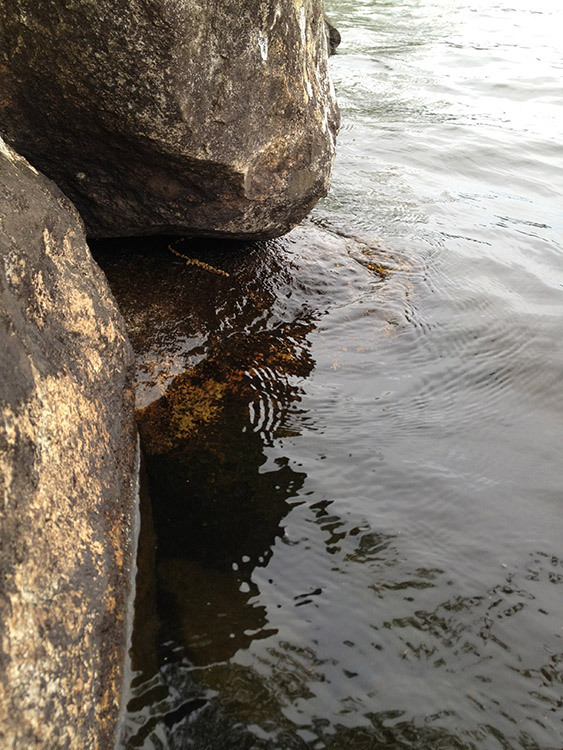 image of boulders on a lakeside with water washing over them in crisp detail